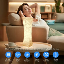 Tall fabric table lamp with textured white shade, warm light on