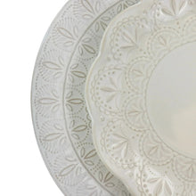 Close-up of embossed floral lace pattern on ceramic plate, off-white