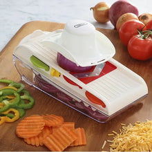 White mandoline slicer with red insert and blade guard on tabletop