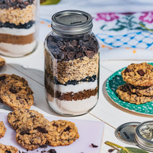 Ball wide-mouth mason jar with lid and band, clear glass; cookie mix inside.