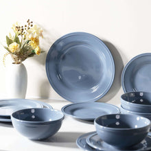 Blue stoneware plates and bowls arranged with a few stacked pieces