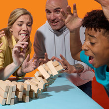 Friends excited while playing a wood tower block game with scattered blocks