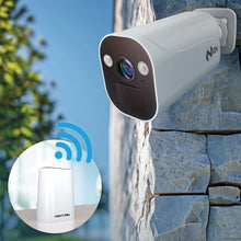 White outdoor spotlight security camera mounted on a wall by an entry