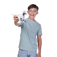 Smiling boy playing with white and blue robotic raptor dinosaur toy, red mouth