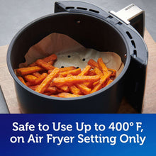 Parchment air fryer liner holding cut fries in an air fryer basket