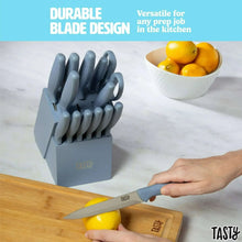 Slate blue stainless steel knife set with hand holding a small paring knife