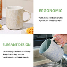 White ceramic mug and blue speckled mug with curved handles, one being poured