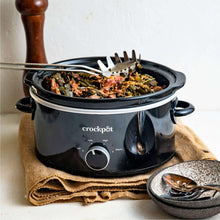 Black slow cooker with lid open, food-filled insert and front control dial shown