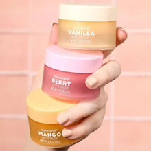Hand holding NatureWell lip mask jars: Vanilla, Berry, and Mango.