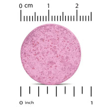 Pink-purple chewable tablet round sample with size ruler markings