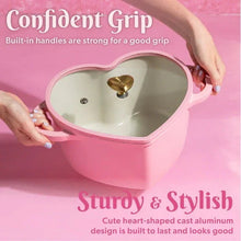 Pink heart-shaped Dutch oven with two side handles and gold heart knob on lid