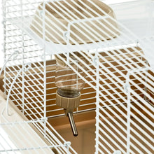 Clear water bottle with metal sipper inside a white wire hamster habitat