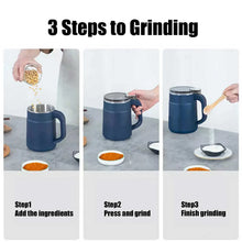 Blue electric spice grinder with side handle and clear lid, shown with ground spices
