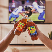 Hands holding Lipton iced tea bottles outdoors, clinking