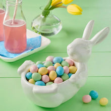 Candy coated milk chocolate eggs in a white bunny-shaped bowl, pastel shells