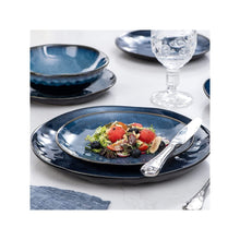 Blue stoneware dinnerware set with oval serving dish, bowls, and plates in speckled glaze