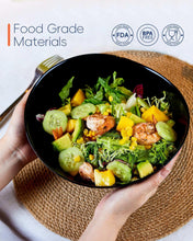 Black ribbed bowl with mixed salad of greens, fruit pieces, and shrimp