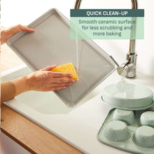 Mint green ceramic nonstick bakeware tray being rinsed for easy cleaning