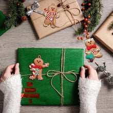 Gingerbread man ornament tied to a green gift box with twine bow