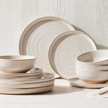 Cream stoneware dinnerware set with swirl pattern plates and bowls
