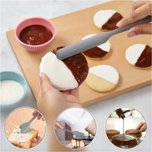 Gray silicone spatula spreading chocolate or frosting over dough rounds