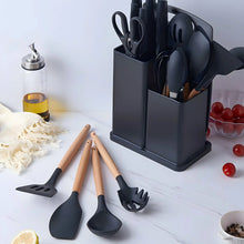 Black silicone cooking utensils in square holder with light wood handles, plus loose tools
