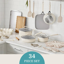 Beige ceramic nonstick cookware set with pots, pans, and kitchen utensils