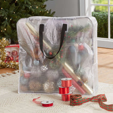 Transparent storage bag with zipper and black handles, filled with gift items