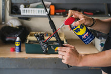 WD-40 lubricant spray can with red straw nozzle for maintenance in a workshop