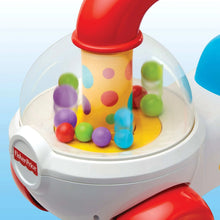 Clear ball dome on a white and red ride-on corn popper toy with colorful pieces