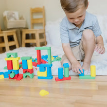 Child building with colorful wooden blocks on a wooden table surface.