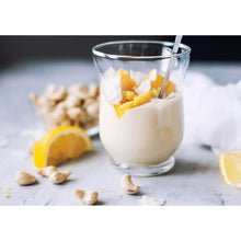 Cashew nuts and cashew cream in a glass with citrus pieces