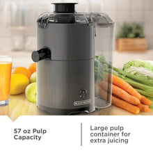 Fruit and vegetable juicer with clear pulp container, black base, and front spout