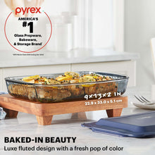 Smoke-tinted rectangular glass baking dish with blue lid, fluted baking design