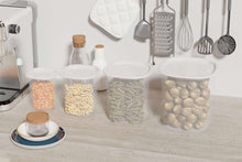 Clear plastic kitchen storage canisters with white lids on countertop