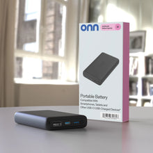 Black portable battery bank with packaging box on tabletop