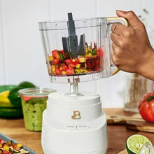 Drew Barrymore 3-cup food chopper with colorful chopped food in clear bowl; hand on handle