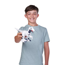Boy holding white and blue electronic robotic raptor dinosaur toy with red mouth