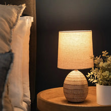 Ceramic table lamp with beige shade and ribbed carved ceramic base