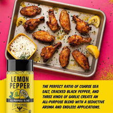 Lemon pepper seasoning bottle with sheet pan of seasoned chicken wings and lemon.