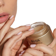 AHAVA smoothing cream jar with open lid as hands scoop cream