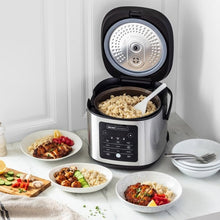 Stainless rice cooker with lid open and cooked rice inside the inner pot