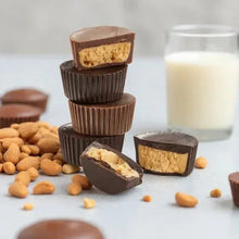 Chocolate peanut butter cups stack with sliced pieces and peanuts