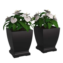 Pair of black planters with artificial flowers and green leaves
