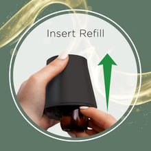 Hand inserting a refill into a black Air Wick essential mist diffuser