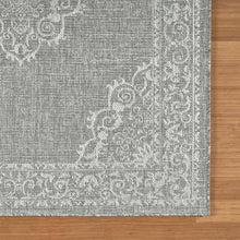 Indoor/outdoor rug corner, light gray with white floral scrollwork border