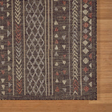 Rug pattern detail with lattice diamonds and small red accents on dark gray
