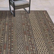 Geometric rug close-up with vertical stripes, diamond motifs, dark gray and tan