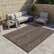 Geometric indoor/outdoor rug with dark gray field and multicolor tribal pattern