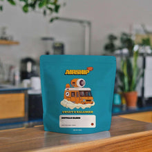 Whole bean coffee bag, teal package with Airship Buffalo Blend front on countertop